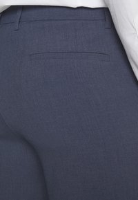 Navy blue tailored trousers with a smooth, textured fabric, featuring a rear pocket and a slim fit design.