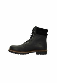 Zwarte leren enkellaars met een suede kraag, ronde neus, zes metalen oogjes en een robuuste zool. Heeft een contrasterende bruine bies op de zool.