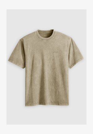 Svetlo rjav kratek rokav majica s krožnim izrezom, izdelana iz mehkega blaga. Ima majhen, vezen logotip na prsih.