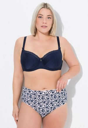 Reggiseno blu navy con motivo a pois testurizzato e bordo ondulato, abbinato a slip a vita alta con stampa floreale in blu navy e rosa chiaro.