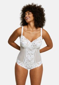 Bodysuit en dentelle blanche avec des sections transparentes, des motifs floraux, des bords en dentelle et des bretelles réglables, conçu pour un look ajusté.