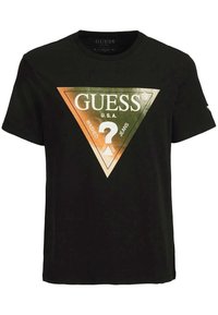 Černé tričko s krátkým rukávem s kovovým trojúhelníkovým logem s nápisy "GUESS U.S.A." a "Washed Jeans" na přední straně.