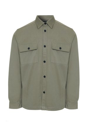 Veste en toile olive en tissu doux, avec un devant boutonné, deux poches poitrine et des boutons noirs. Coupe ajustée, manches longues.