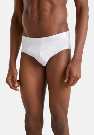 Slip in cotone bianco con una morbida cintura elastica. Presenta un design aderente e una texture liscia, adatto per l'uso quotidiano.