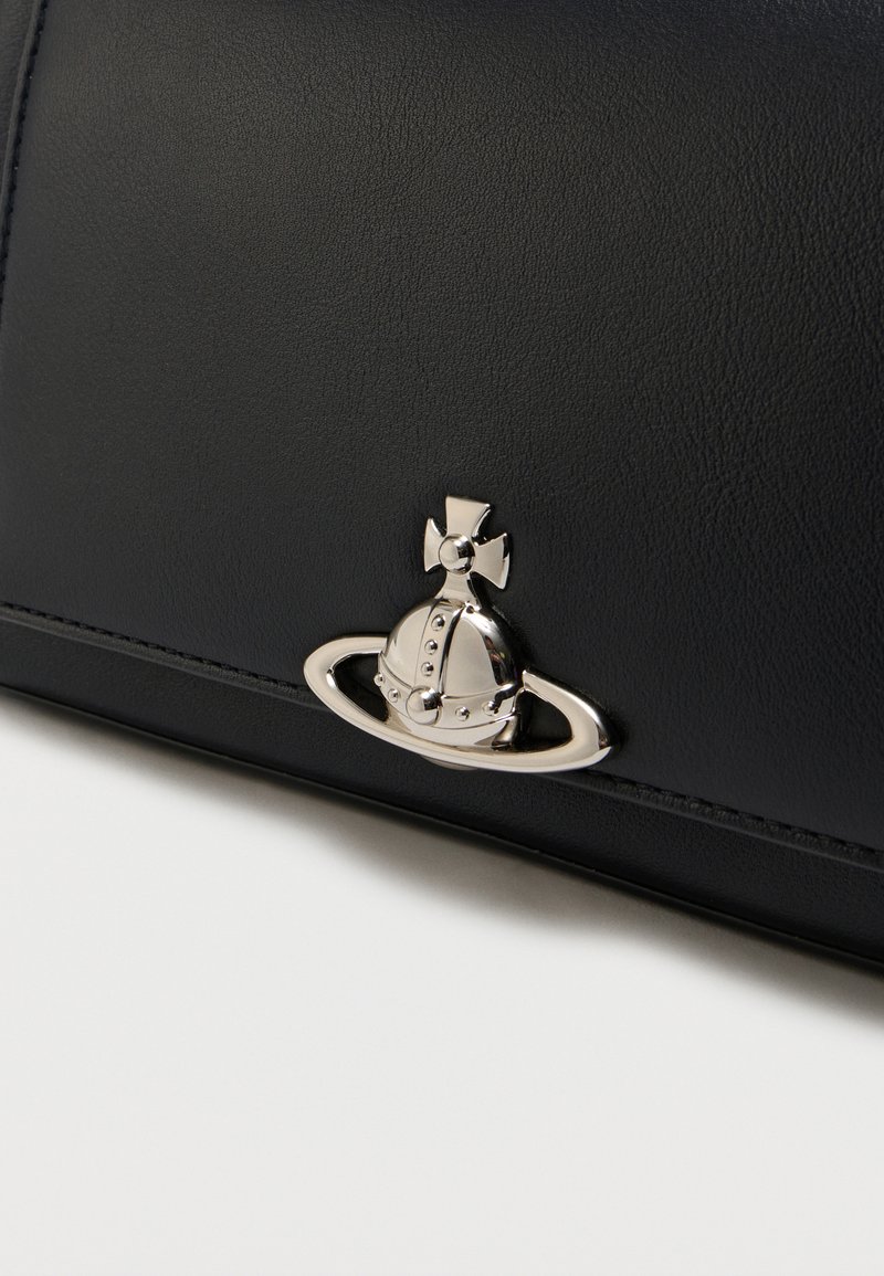 Black leather surface with a small silver emblem featuring a crowned sphere encircled by an orbit-like ring.