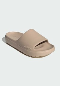 Beige sandal med öppen tå, tillverkad av ett slätt material, med en tjock sula med en vågig textur och präglad logotypdetalj.