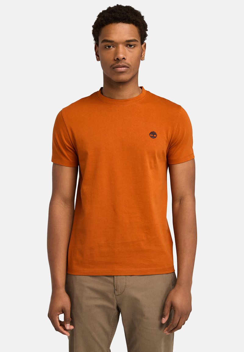 Orange bomulds t-shirt med rund hals og korte ærmer. Har et lille logo på brystet. Glat tekstur og normal pasform.
