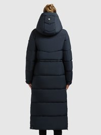 Hosszú, sötét tengerészkék bélelt kabát kapucnival, vízszintes steppelt részekkel és egy kerek logórésszel a hátoldalán.