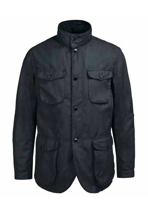 Veste noire avec un col haut, quatre poches frontales, fermeture à boutons et une finition textile texturée. Design classique avec des caractéristiques pratiques.