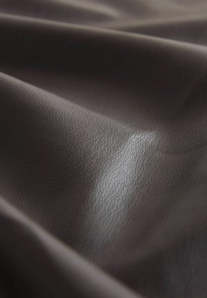 Tessuto in pelle di colore marrone scuro, con texture, morbide pieghe, leggera lucentezza e un motivo superficiale a ciottoli, adatto per rivestimenti o lavori di artigianato.