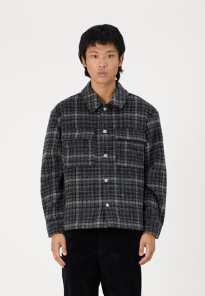 Gray and black plaid shirt jacket with a collared neckline, snap buttons, and two front pockets, made from a textured fabric.