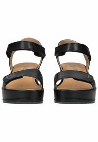 Sandali in pelle nera con due cinghie regolabili, punta aperta e suola a piattaforma spessa. Soletta in materiale imbottito marrone con perforazioni. Motivo a battistrada circolare.