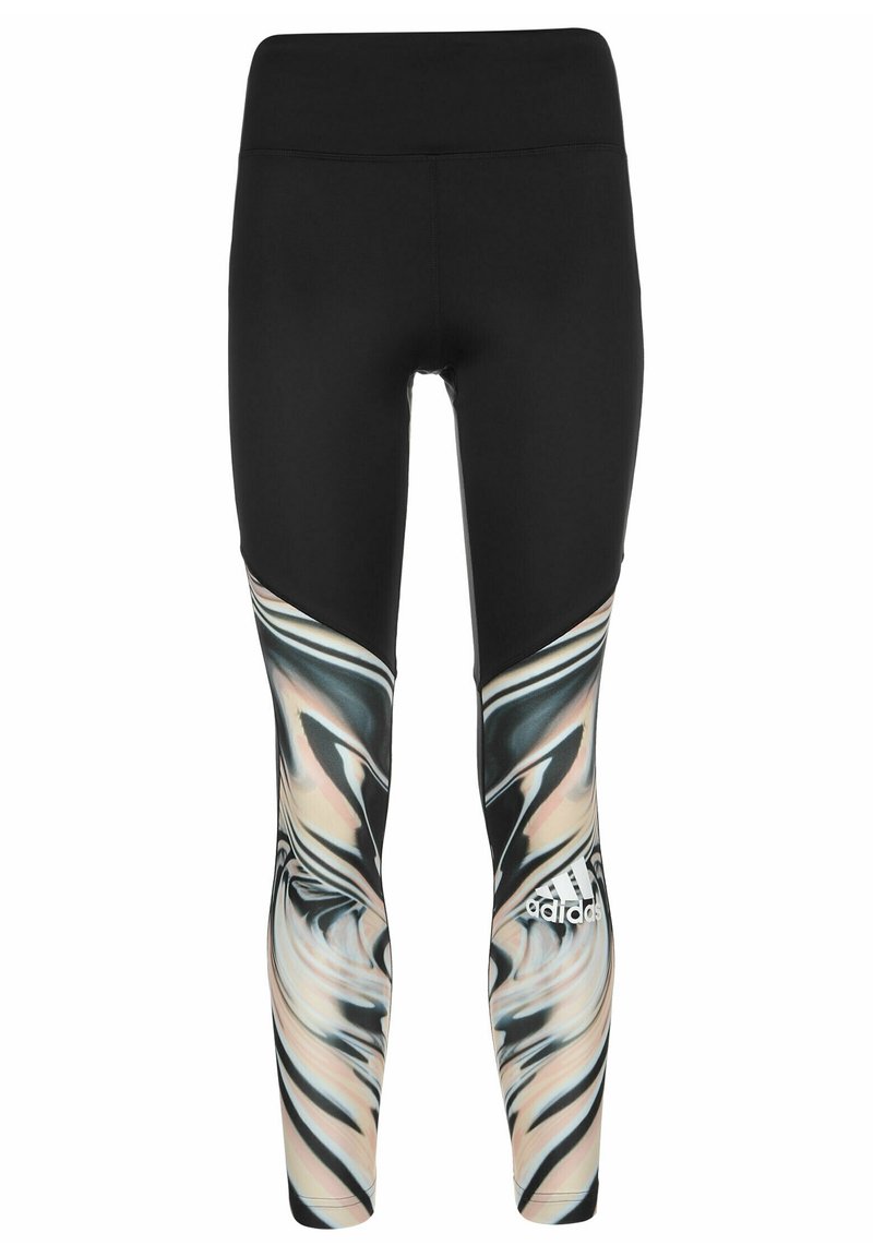 Leggings noirs avec une silhouette ajustée, présentant un motif marbré multicolore dans des teintes de beige, noir et blanc sur les côtés inférieurs.