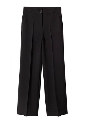 Kobieta w czarnej skórzanej kurtce na białym swetrze z ciemnoszarym wzorem w romby i skrzyżowanymi liniami, w połączeniu z czarnymi spodniami.