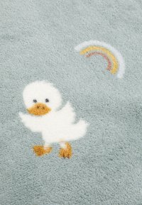 Soft blue rug with a fluffy white duck design and a rainbow. The textured surface features detailed stitching for added depth.