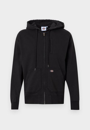 Svart zip-up hoodie i mjukt material; har en framzipper, snörning i huven och två stora framfickor. Utmärkande logotyp på lappen.