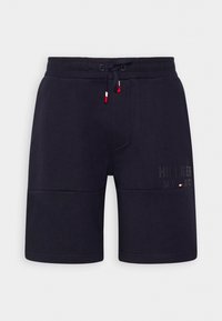 Pantalones cortos casuales azul marino con cintura elástica, cordón con puntas rojas y blancas, y sutil logo "Hilfiger NY 85" en la pierna derecha.