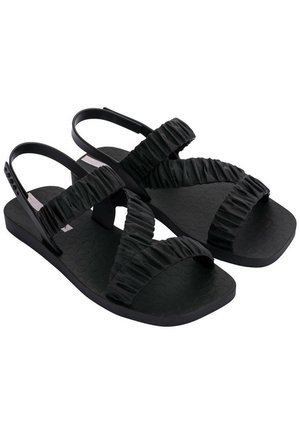Czarne sandały z teksturowaną gumową podeszwą, z marszczonymi paskami z materiału i minimalistycznym designem. Regulowany pasek na pięcie dla lepszego dopasowania.