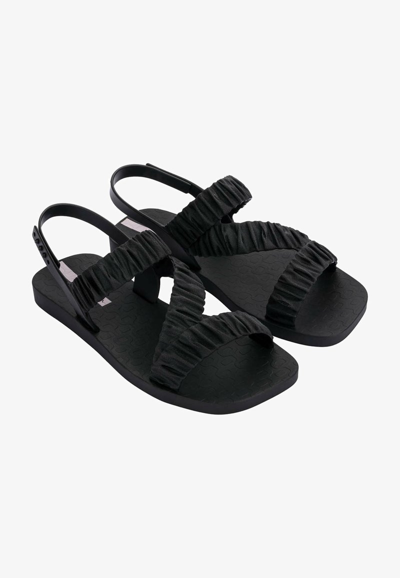 Sandales noires avec une semelle en caoutchouc texturé, dotées de brides en tissu froncé et d'un design minimaliste. Bride de talon réglable pour un meilleur ajustement.