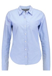 Camicia button-up azzurro chiaro in cotone, con colletto a punta, maniche lunghe e taschino sul petto. Design semplice con bottoni bianchi.