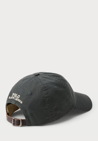 Căciulă din bumbac de un albastru închis cu curea ajustabilă din piele maro, având brodat pe spate logo-ul "Polo Ralph Lauren". Design clasic.