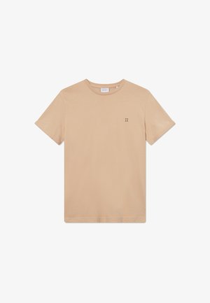 T-shirt en coton beige à manches courtes, col rond, et un petit logo "II" en vert foncé sur la partie gauche de la poitrine. Texture lisse.