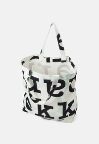 Sac fourre-tout en toile avec un fond blanc, de grandes lettres noires et un motif gris subtil. Doté de deux poignées solides. Design à ouverture supérieure.