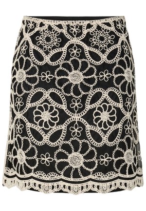 Jupe noire avec broderie en dentelle florale blanche complexe et détail d'ourlet festonné.