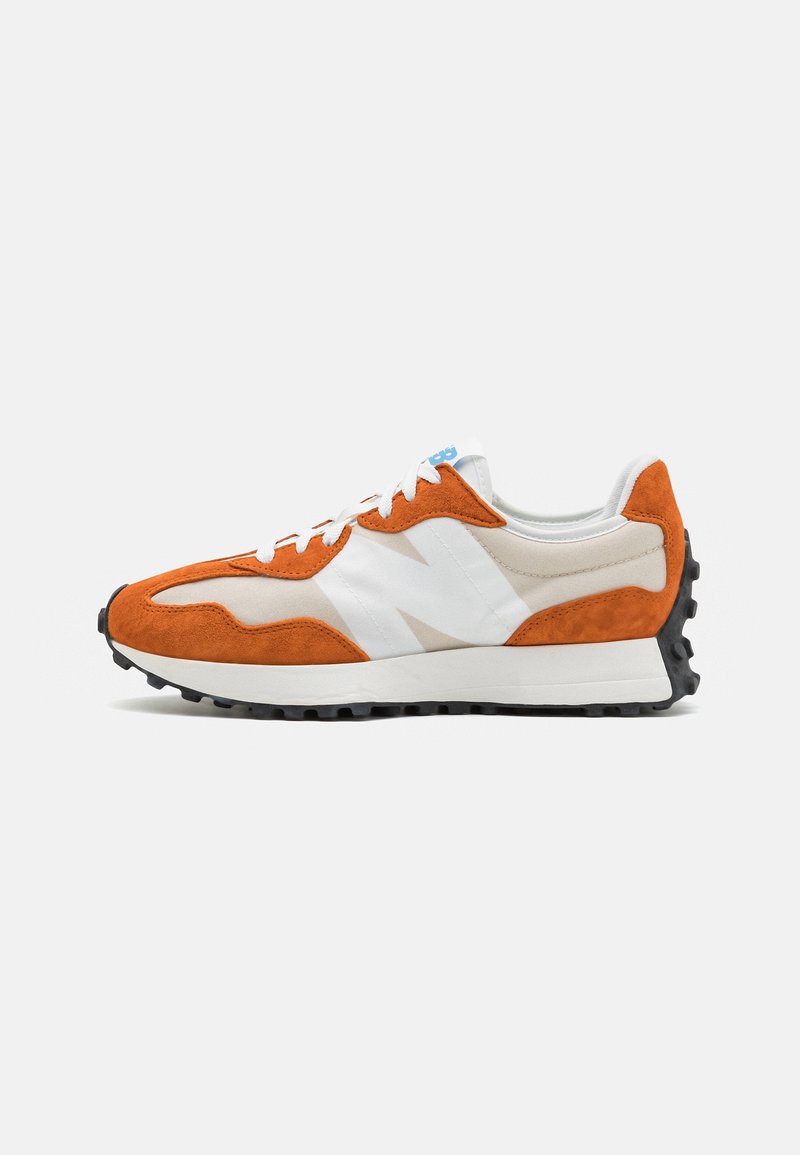 Chaussure de course en suède orange et blanc avec mesh, lacets blancs et semelle texturée noire, vue de côté sur fond uni.