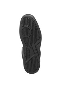 Černá gumová podrážka boty se strukturovaným vzorkem, kruhovou gripovou částí a embosovaným logem "Reebok" na boku.