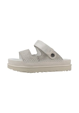 Sandalo beige UGG senza lacci con due larghe fasce testurizzate, chiusura regolabile in Velcro e suola spessa con dettagli cuciti.