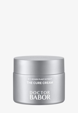 Pot argenté de Doctor Babor « The Cure Cream » avec le texte 15 % Biogen Plant Extract sur un fond blanc uni.
