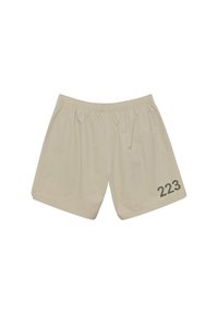 Ljusbruna shorts gjorda av lätt tyg, med ett elastiskt midjeband och ett stort "223" tryckt i mörkgrått på vänster sida.