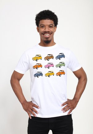 White t-shirt featuring nine colorful car illustrations in rows, including orange, blue, green, pink, and yellow, on a smooth fabric.