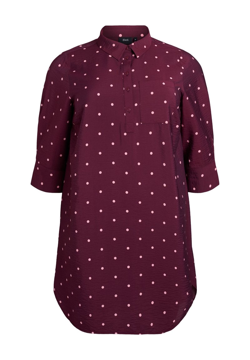 Burgundy skjorta med vita prickar, knappp front, krage, långa ärmar och bröstficka. Sömmen har en rundad kant. Lättviktsmaterial.