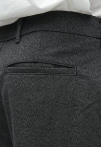 Pelēkas piegrieztas bikses ar teksturētu aujumu, ar aizmugurējo kabatu šauru atveri un jostas cilpām pie jostasvietas.
