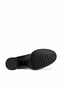 Semelle de chaussure noire avec motif strié et talon circulaire. Texture lisse au niveau du plateau, avec un bord légèrement surélevé pour le soutien.