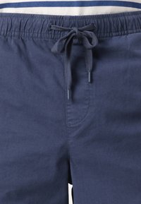 Mørkeblå badeshorts med elastisk talje, justerbar snor og en sidelomme. Glat tekstur og enkelt design.