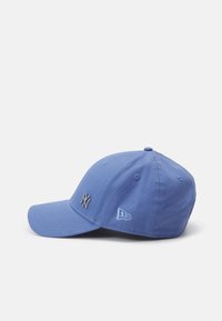 Cappellino da baseball blu chiaro con visiera curvata, dotato di logo ricamato e fori per la ventilazione. Realizzato in materiale di cotone.
