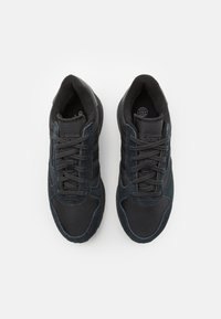 Scarpe sportive nere con tomaia in mesh e dettagli in suede. Chiusura con lacci, colletto imbottito e suola testurizzata per una buona aderenza.