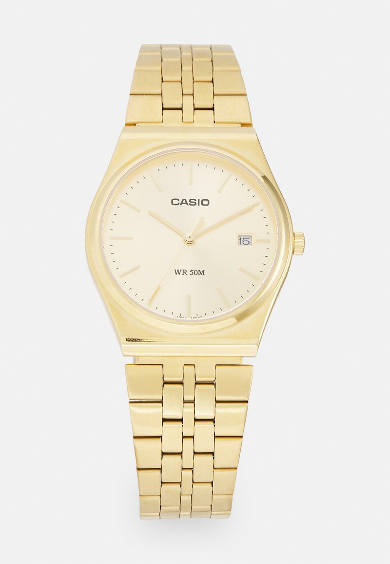 Gold Casio watch with a round face and a textured gold metal band. Features a light gold dial, black hour markers, and a date window. Water-resistant to 50m.