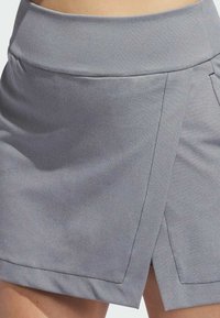 Siva omotna suknja od glatkog, laganog materijala, s širokim pojasom i kontrastnim detaljima šava za moderni dizajn.