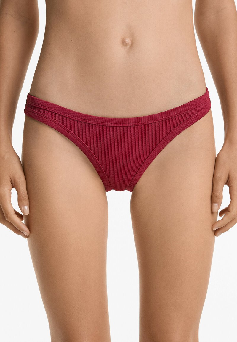 Röd ribbad bikiniunderdel med en slät yta, med en djup skärning och bred midja, lämplig för badkläder.