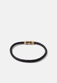 Bracelet en cuir tressé noir avec fermoir magnétique cylindrique en or sur fond blanc.