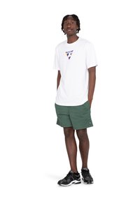 T-shirt bianca a maniche corte con un logo triangolare colorato sul petto, abbinata a pantaloni corti verdi e scarpe da ginnastica nere.