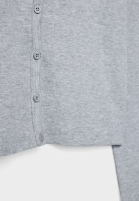 Grå ribbad cardigan med knappstängning och slät textur. Fem knappar i matchande nyans förbättrar plaggets design.