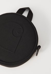 Round, black fabric case with a textured, embossed design. Features a zippered closure and a fabric handle for portability.