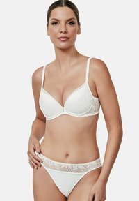 Witte kanten bh en bijpassende string. De bh heeft een gegolfde rand, onder draad steun en verstelbare bandjes. De string heeft kantdetails.