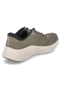 Scarpa da atletica verde oliva con tomaia in rete, colletto imbottito e suola leggermente colorata e tassellata. Presenta sei occhielli per i lacci.