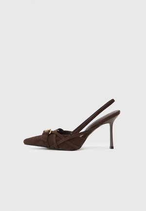 Braune Wildleder Slingback-Schuhe mit hohen Absätzen und spitzer Zehenpartie, ausgestattet mit gekreuzten Riemen und einem goldenen Schnallenakzent.